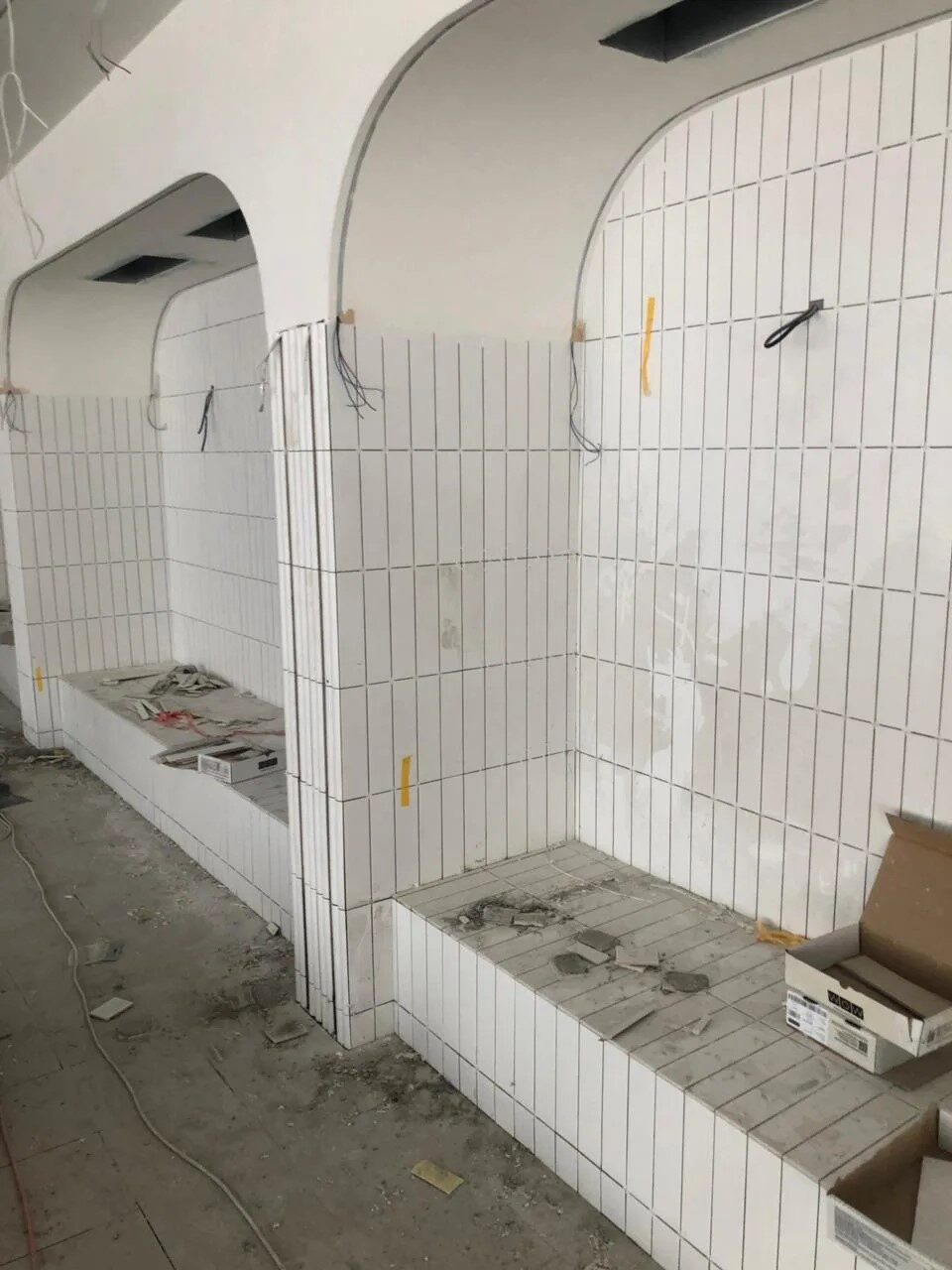 Облицовка арок и скамей белой плиткой во время работ